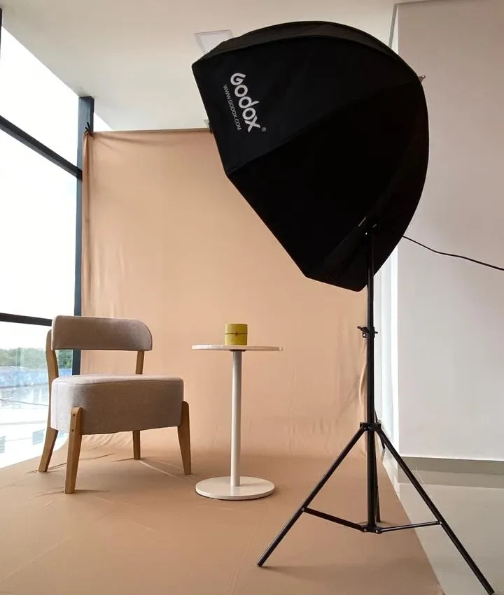 Estúdio fotográfico minimalista com fundo infinito branco e equipamento de iluminação profissional